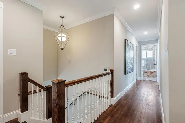 a view of a hallway with wooden floor and staircase
