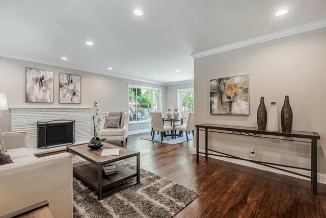 a living room with furniture a fireplace and paintings on the wall
