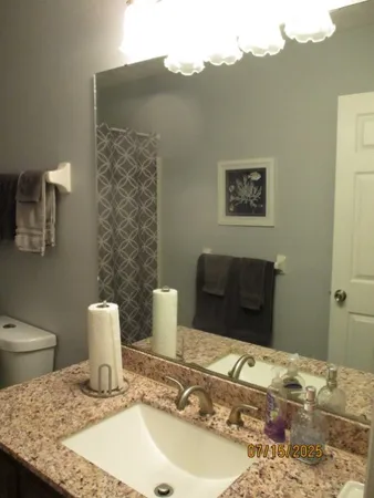 a bathroom with a granite countertop sink and a mirror