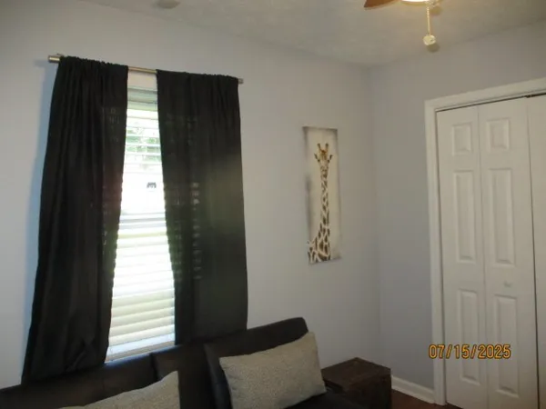 a view of a dining room with furniture a chandelier and a window