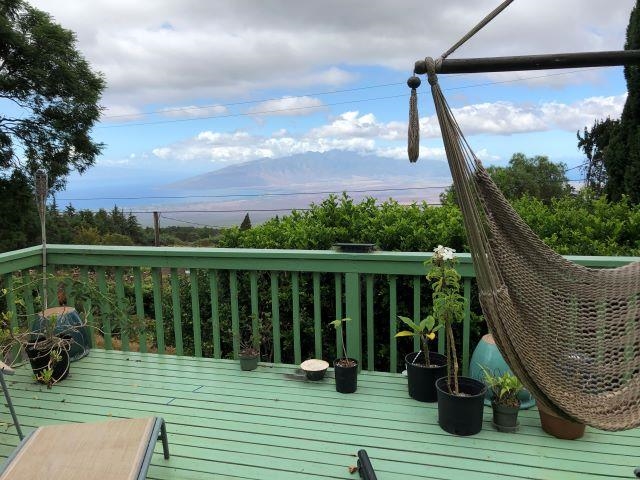 246 Koheo Road Kula, HI 96790 - Photo 23 of 24 a balcony with wooden floor table and chairs