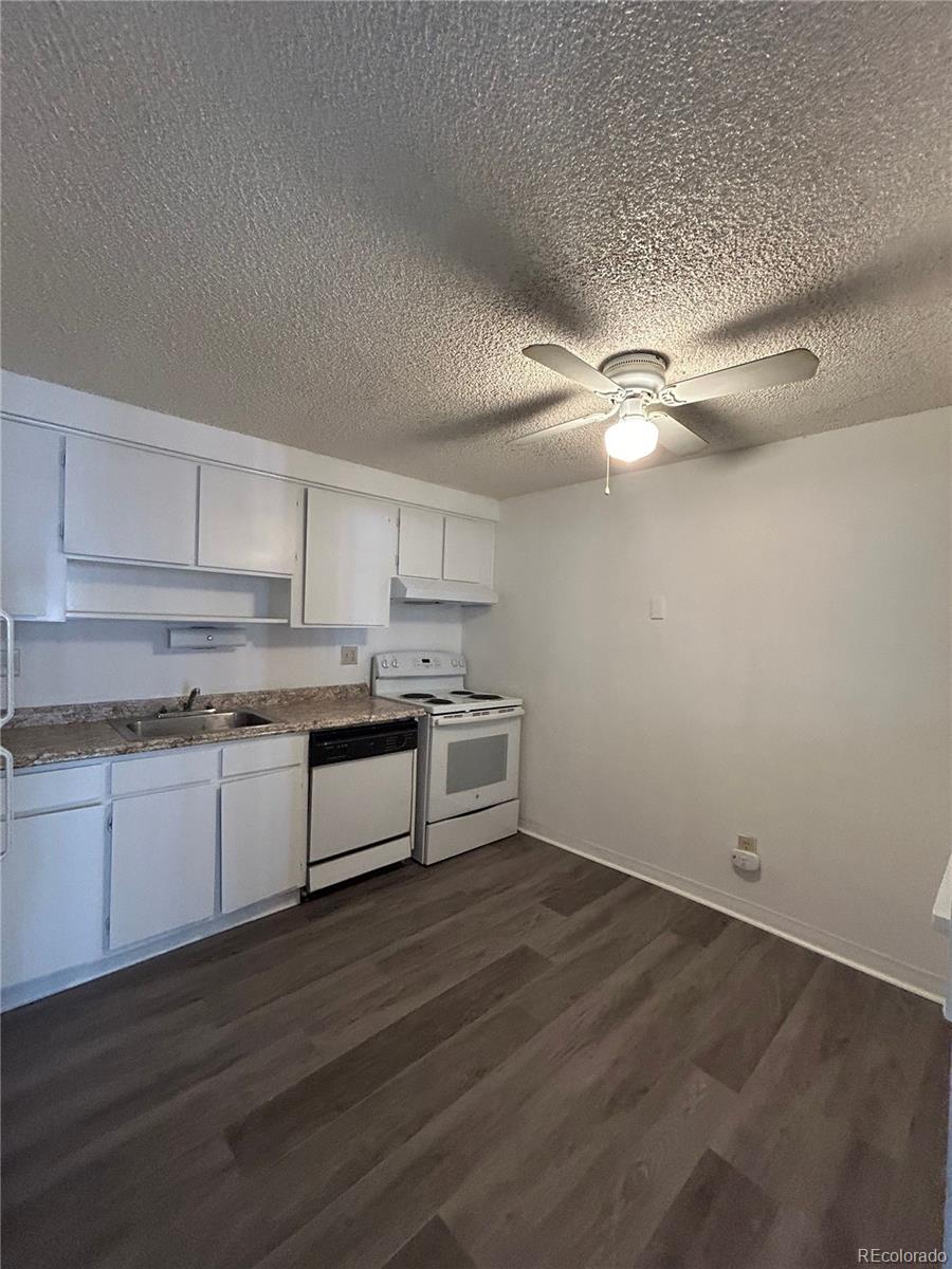 1306 South Parker Road, Unit 167 Denver, CO 80231 - Photo 2 of 14 a kitchen with stainless steel appliances white cabinets and wooden floor