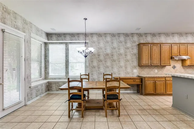 a view of a kitchen with granite countertop a table and chairs in it
