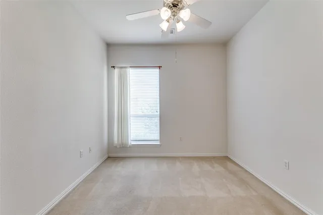 an empty room with a chandelier fan