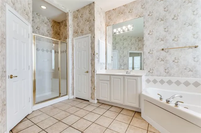 a bathroom with a bathtub sink vanity and mirror