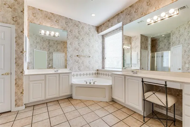 a bathroom with a sink a vanity a mirror and a bathtub