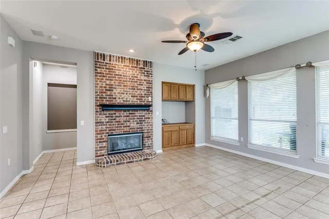 a view of an empty room with a fireplace and a window