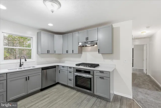 a kitchen with a stove sink and cabinets
