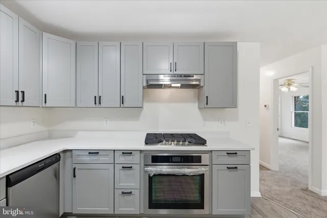 a kitchen with granite countertop white cabinets and stainless steel appliances