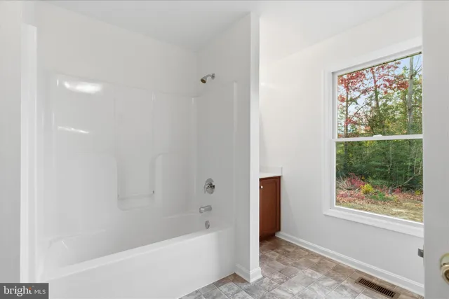 a bathroom with a bathtub and window