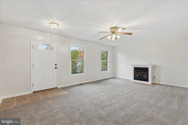 an empty room with windows and a fireplace