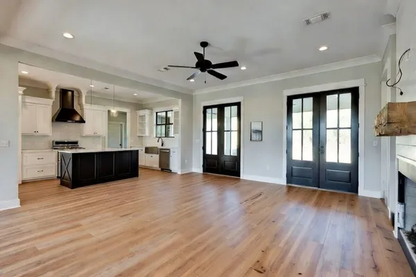 a view of an empty room with window and wooden floor