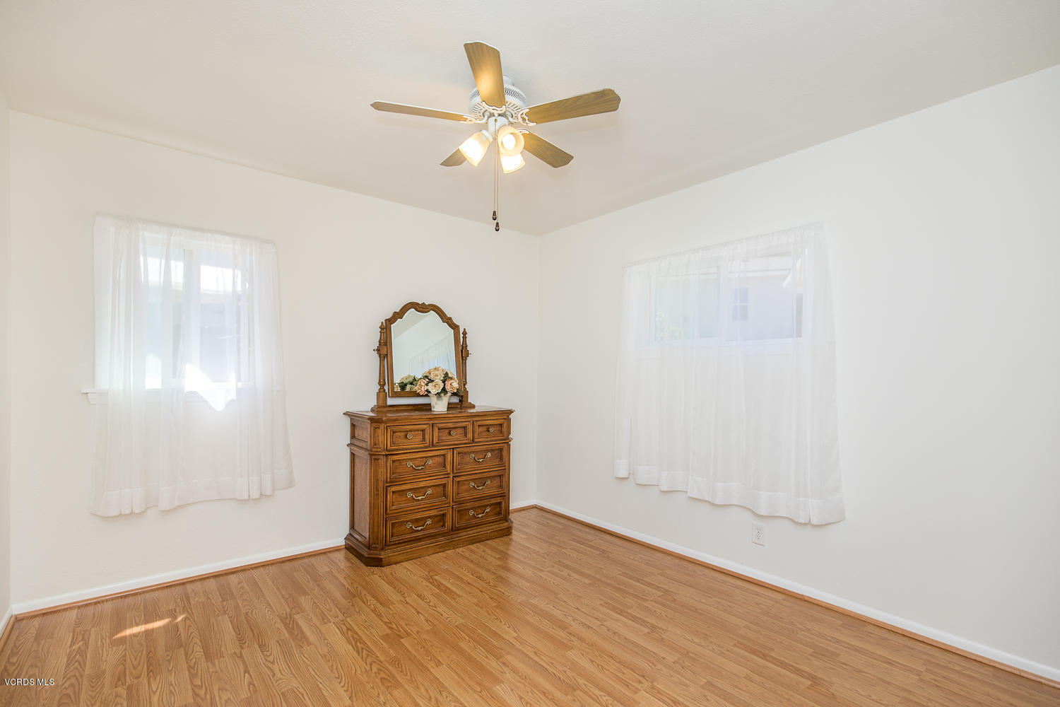 250 Brook Road Newbury Park, CA 91320 - Photo 11 of 18 an empty room with wooden floor fan and windows