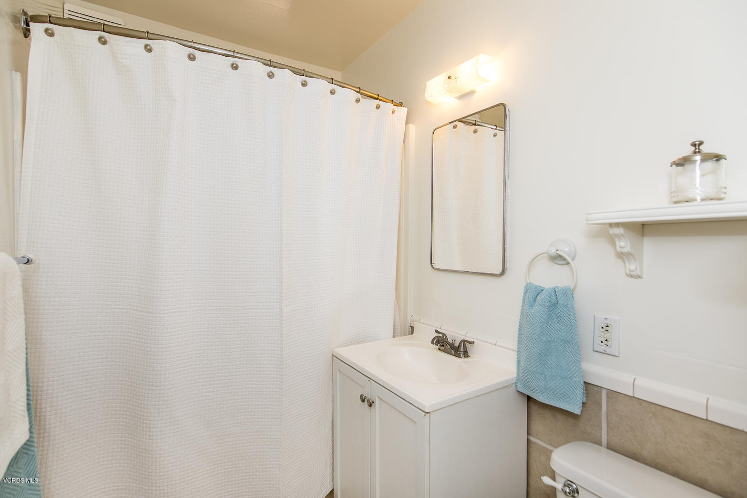 250 Brook Road Newbury Park, CA 91320 - Photo 10 of 18 a bathroom with a sink a mirror and a shower curtain