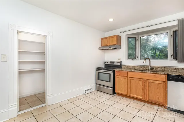 a kitchen with granite countertop a sink and a stove top oven