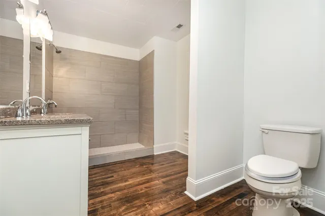a bathroom with a granite countertop sink toilet and shower