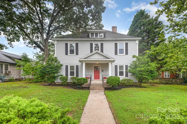 a front view of a house with a garden and yard