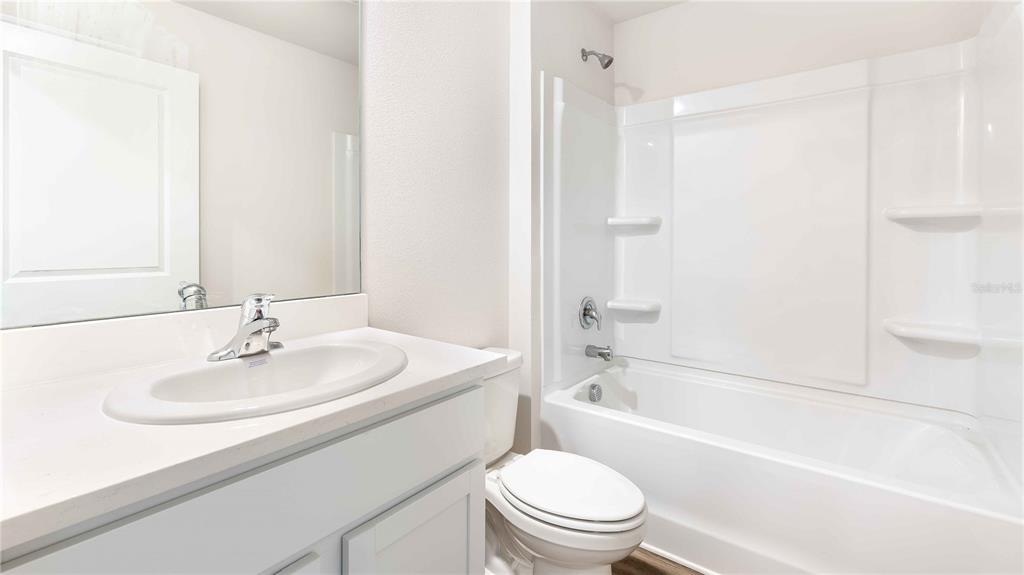 10931 Rabbit Grove Trail Palmetto, FL 34221 - Photo 14 of 30 a bathroom with a sink a toilet and a bathtub