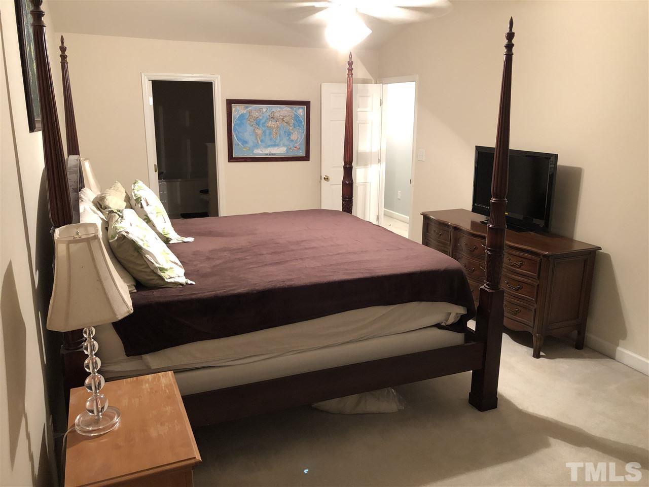 5426 Goldenglow Way Raleigh, NC 27606 - Photo 12 of 25 a bedroom with a bed closet and flat screen tv