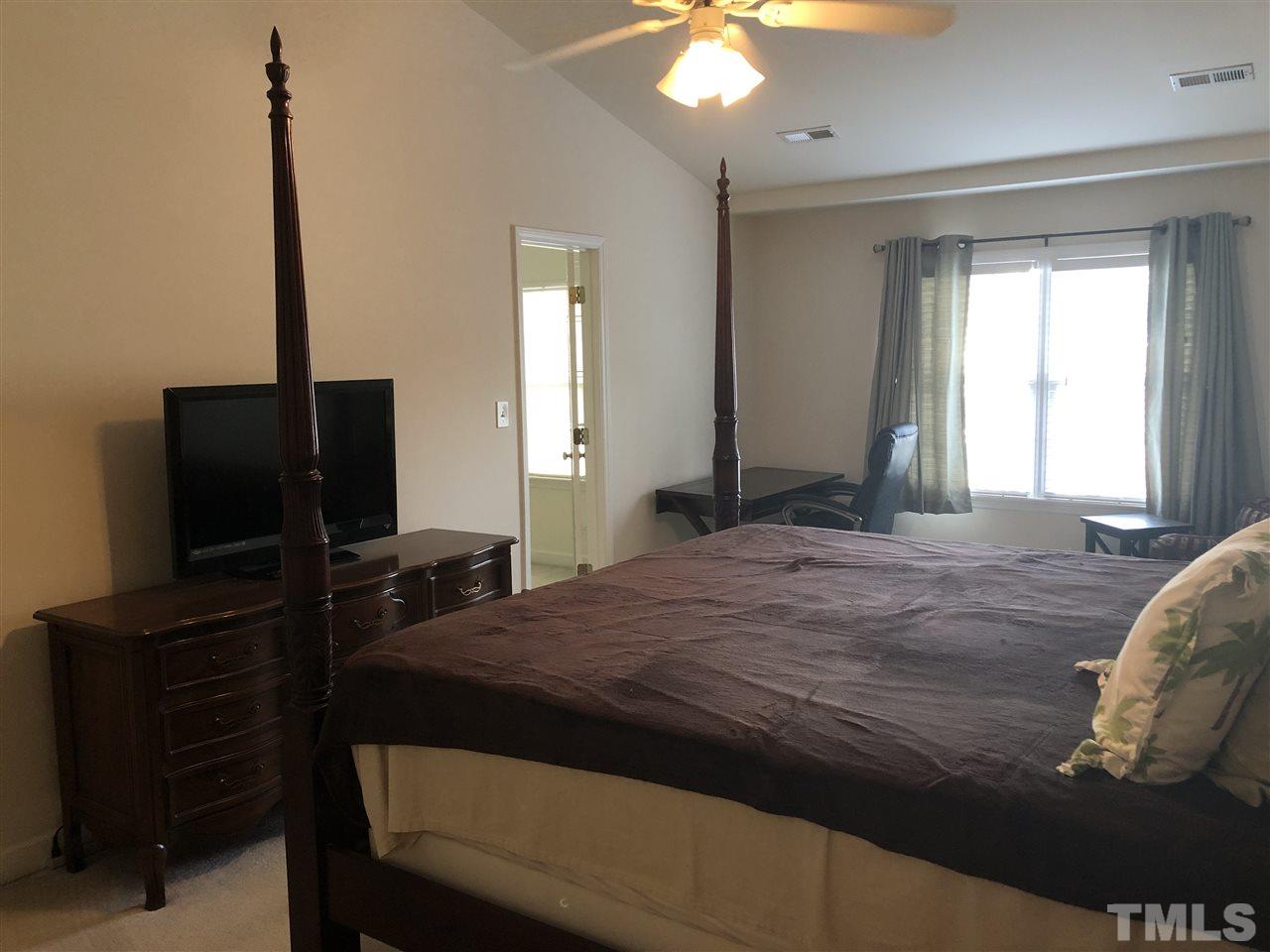 5426 Goldenglow Way Raleigh, NC 27606 - Photo 14 of 25 a bedroom with a bed and a flat screen tv