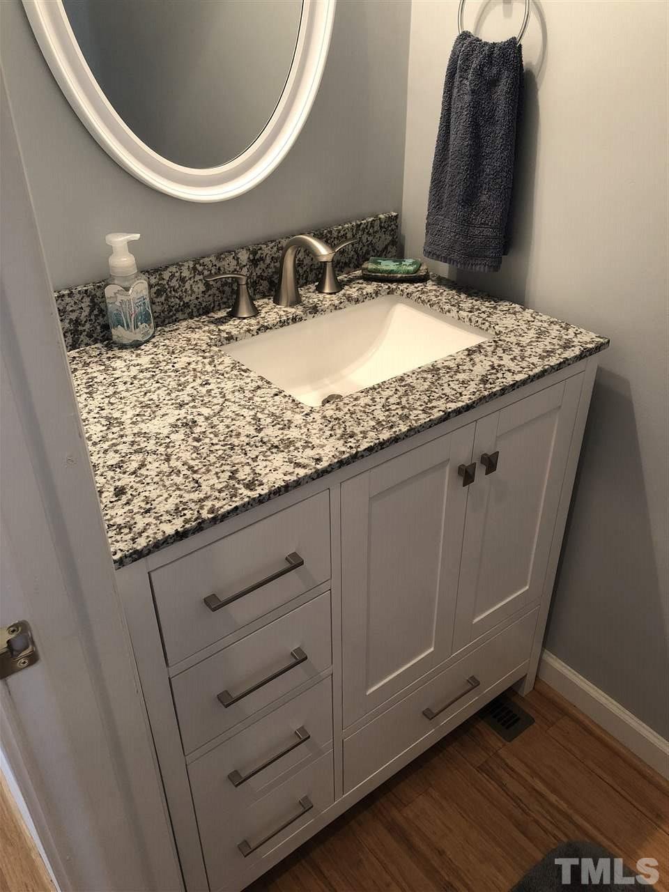 5426 Goldenglow Way Raleigh, NC 27606 - Photo 18 of 25 a bathroom with a granite countertop sink and a mirror