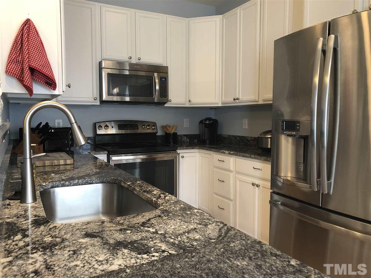 5426 Goldenglow Way Raleigh, NC 27606 - Photo 3 of 25 a kitchen with granite countertop a refrigerator stove and microwave