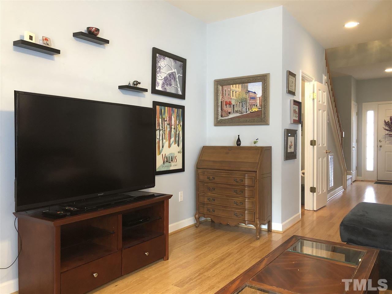 5426 Goldenglow Way Raleigh, NC 27606 - Photo 8 of 25 a living room with furniture and a flat screen tv