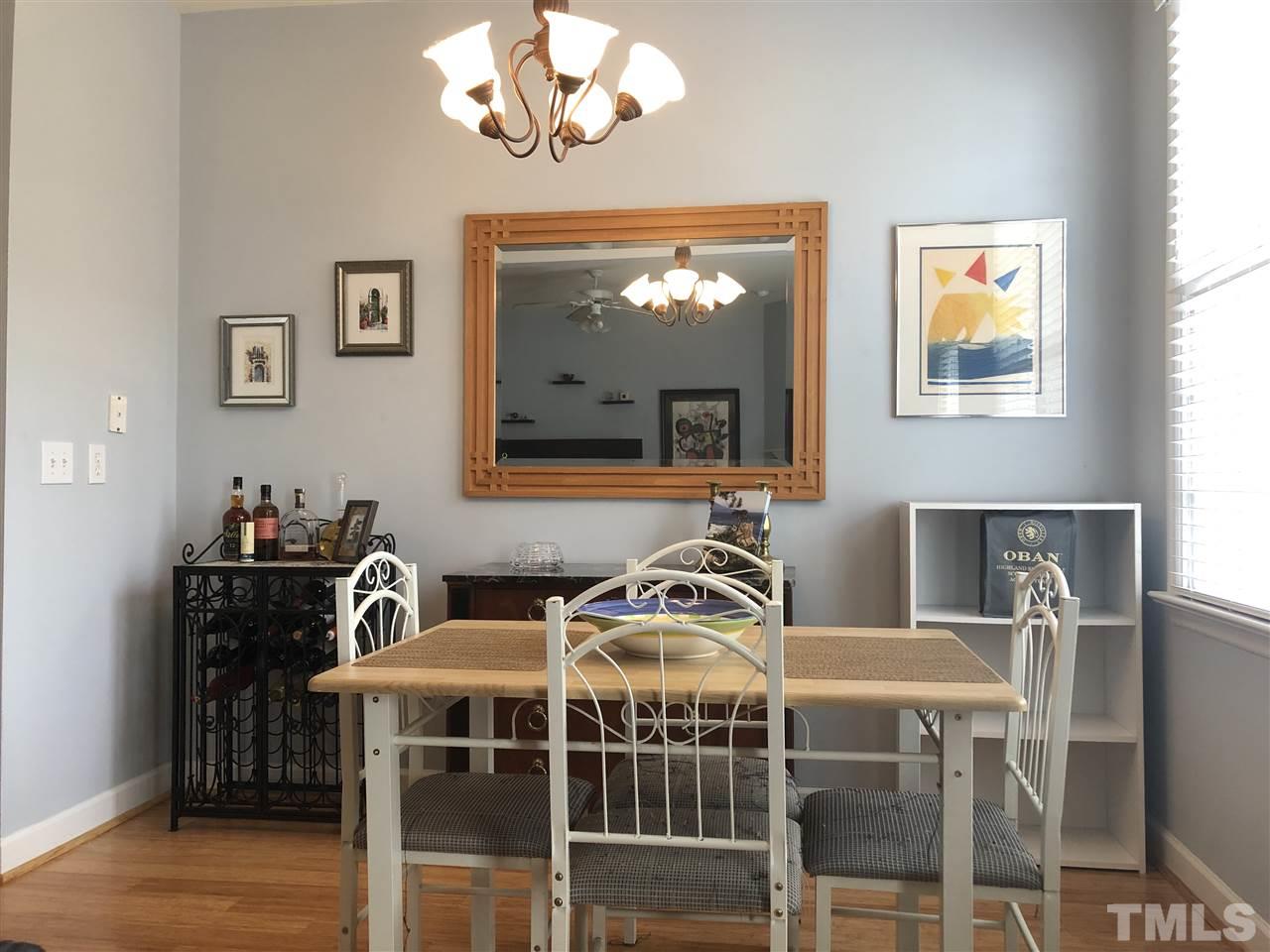 5426 Goldenglow Way Raleigh, NC 27606 - Photo 9 of 25 a view of a dining room with furniture a chandelier and wooden floor