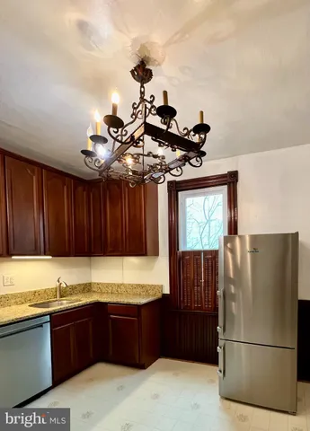 a kitchen with granite countertop wooden cabinets and stainless steel appliances