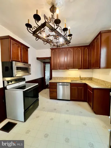 a large kitchen with stainless steel appliances granite countertop a sink dishwasher stove and cabinets
