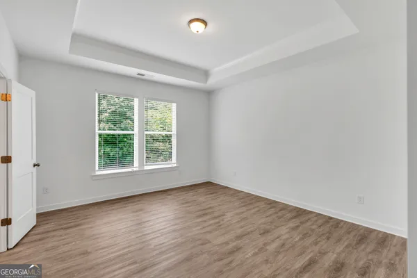 an empty room with wooden floor and window