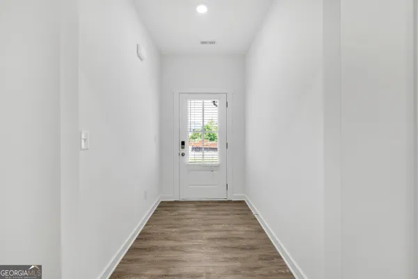 a view of a hallway with wooden floor and a window
