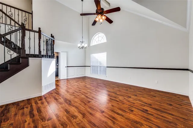 a view of a livingroom with wooden floor and a ceiling fan