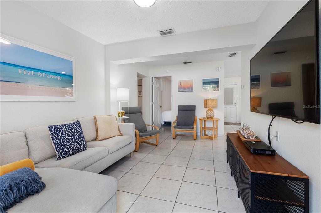 614 Gulf Boulevard, Unit 9 Indian Rocks Beach, FL 33785 - Photo 13 of 41 a living room with furniture and a flat screen tv