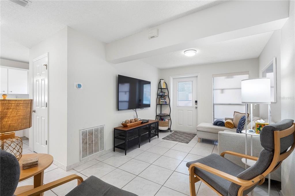 614 Gulf Boulevard, Unit 9 Indian Rocks Beach, FL 33785 - Photo 15 of 41 a living room with furniture a flat screen tv and a window