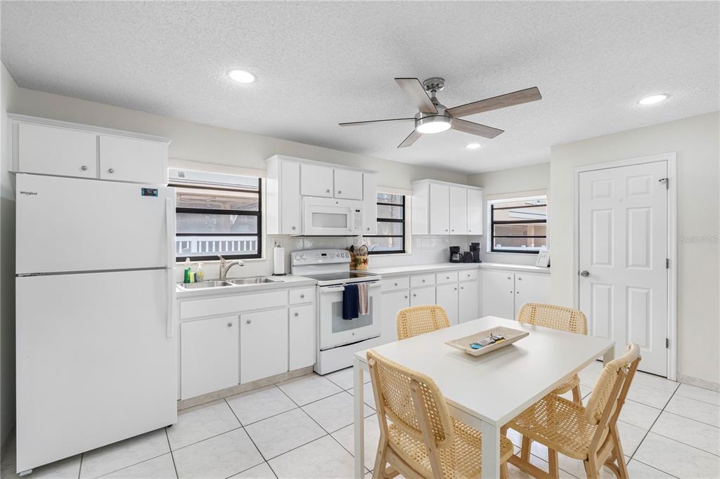 614 Gulf Boulevard, Unit 9 Indian Rocks Beach, FL 33785 - Photo 21 of 41 a kitchen with white cabinets and white appliances