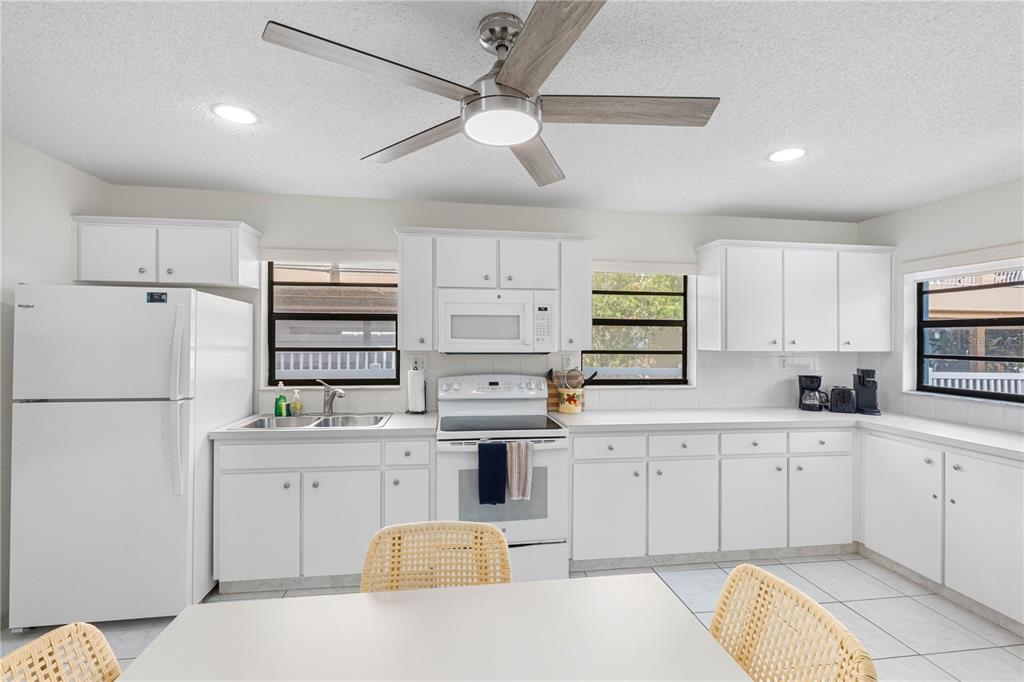 614 Gulf Boulevard, Unit 9 Indian Rocks Beach, FL 33785 - Photo 22 of 41 a kitchen with a sink white cabinets and stainless steel appliances
