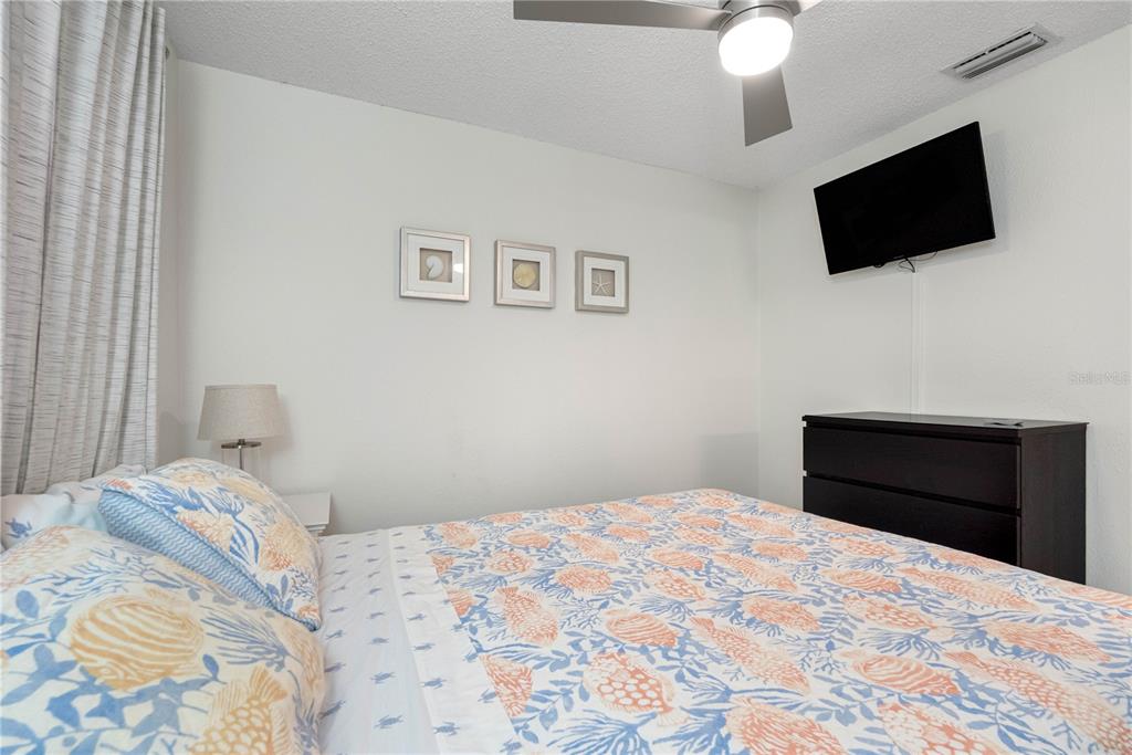 614 Gulf Boulevard, Unit 9 Indian Rocks Beach, FL 33785 - Photo 27 of 41 a bedroom with a bed and a flat screen tv
