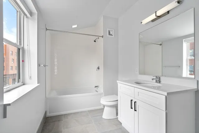 a bathroom with a tub sink toilet and a mirror
