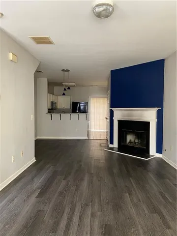 a view of empty room with wooden floor and fireplace