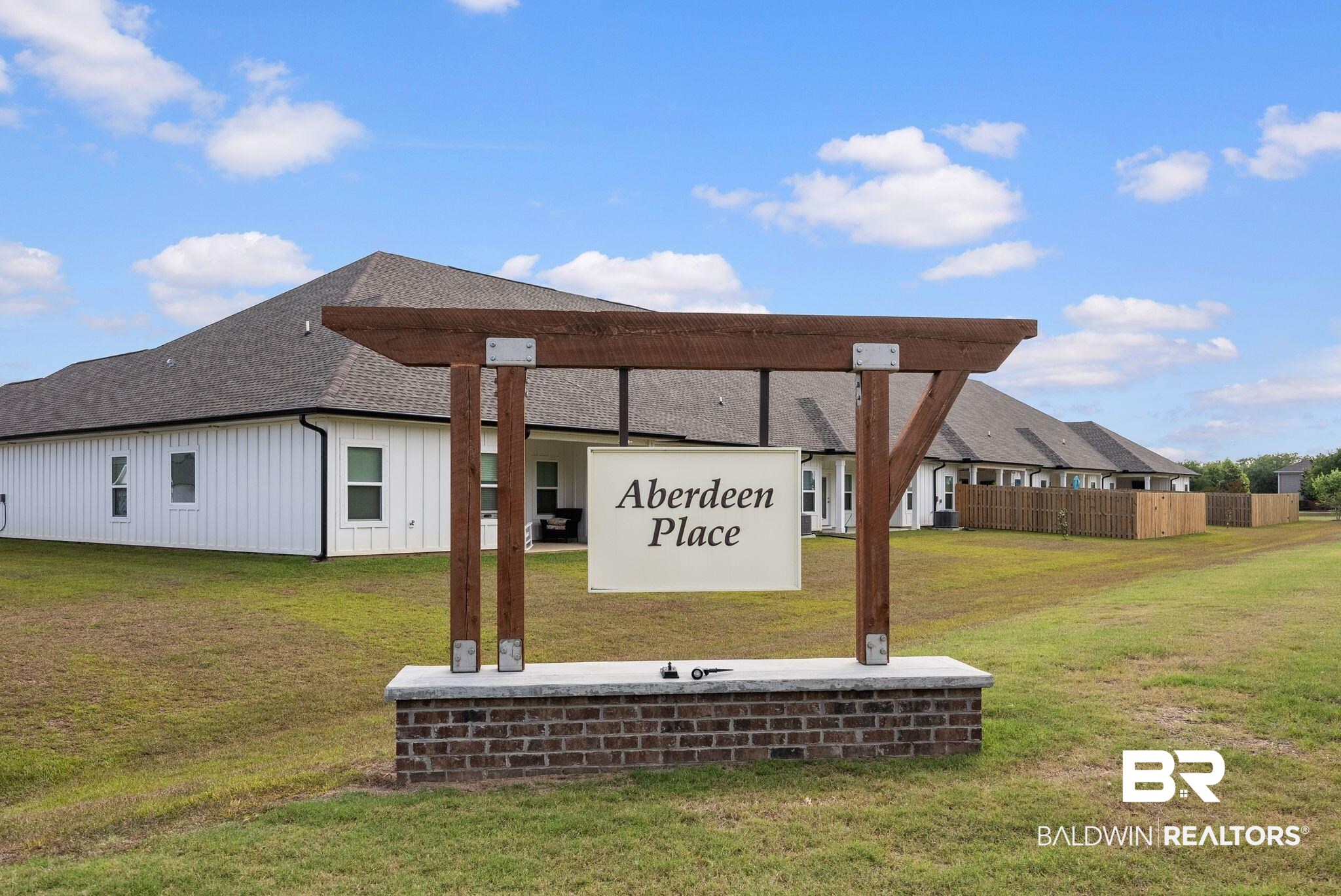 9899 Willet Way Foley, AL 36535 - Photo 37 of 37 Community entrance sign featuring a wood pergola atop a brick and stone base
