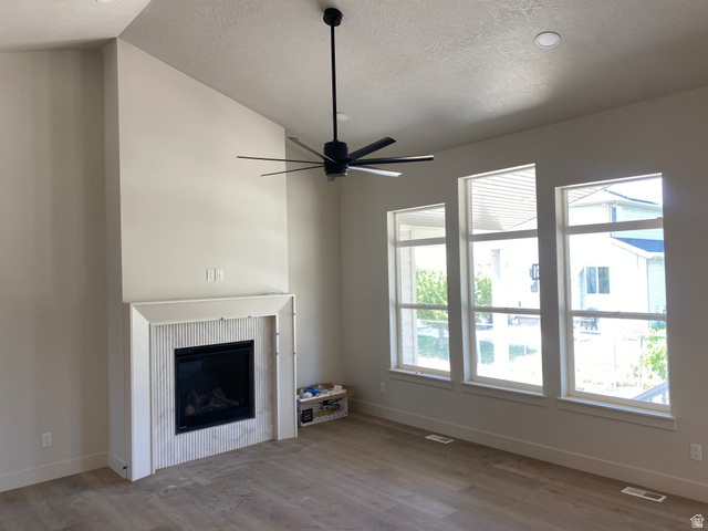 4676 West 75 North, Unit 401 West Point, UT 84015 - Photo 17 of 25 Vaulted ceilings complementing a modern fireplace with fluted tile surround and a clean mantel