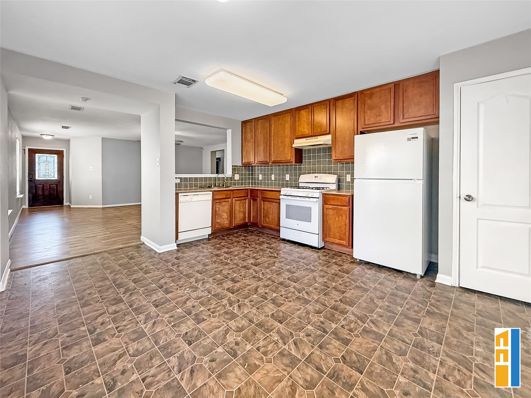 29566 North Legends Bend Drive Spring, TX 77386 - Photo 11 of 21 This inviting kitchen features warm wood cabinetry, a modern tile backsplash, and seamlessly connects to the open living area, perfect for both daily living and entertaining.