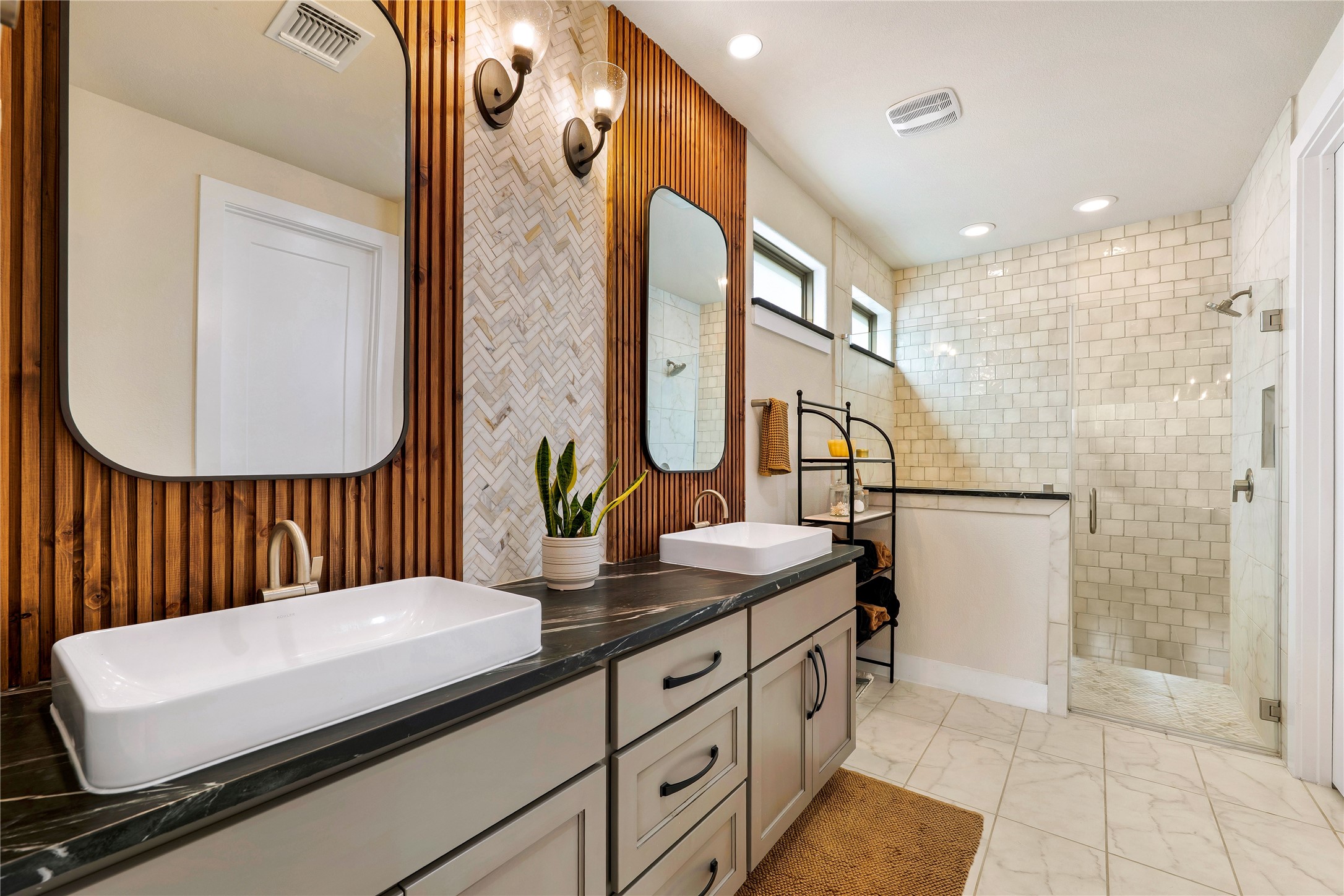 2408 Nate's Place Georgetown, TX 78633 - Photo 19 of 40 Dual vessel sinks and a spacious walk-in shower elevate this bathroom's design.