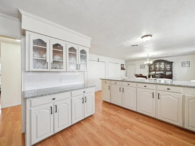 a kitchen with granite countertop white cabinets and white appliances