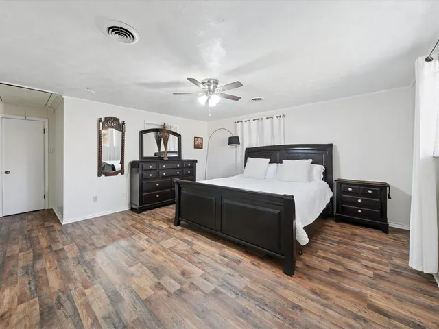 a spacious bedroom with a bed and a chandelier