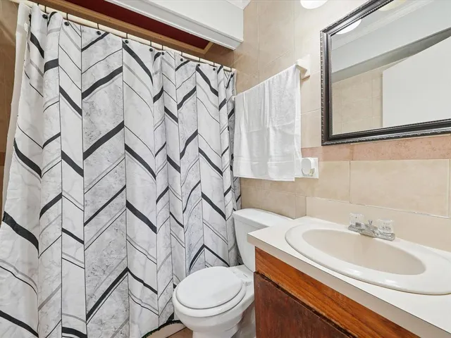 a bathroom with a sink a toilet and shower curtain
