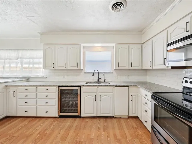 a kitchen with cabinets a sink and appliances