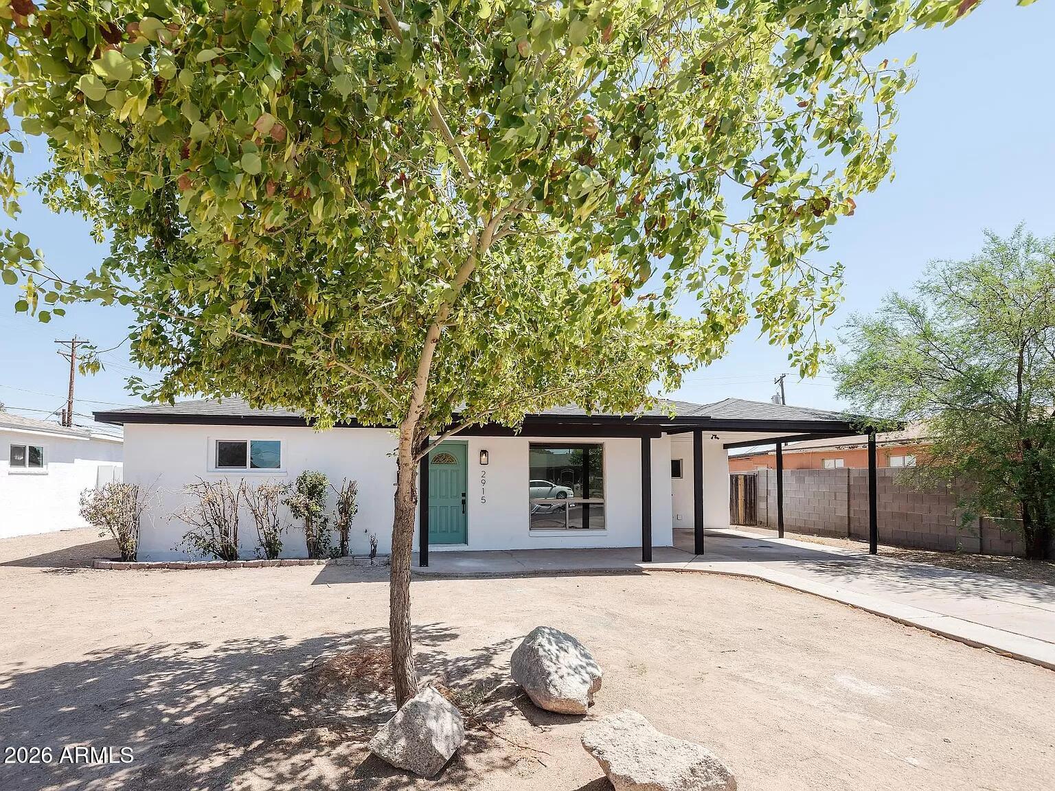 a front view of a house with a tree