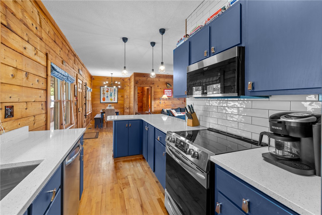 203 Little Lane Seneca, SC 29672 - Photo 11 of 48 This inviting kitchen showcases natural wood walls and a sleek cooking space, perfect for culinary endeavors.
